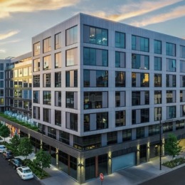exterior of building with green turf and some seating