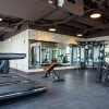 fitness center with rows of treadmills and modern style flooring